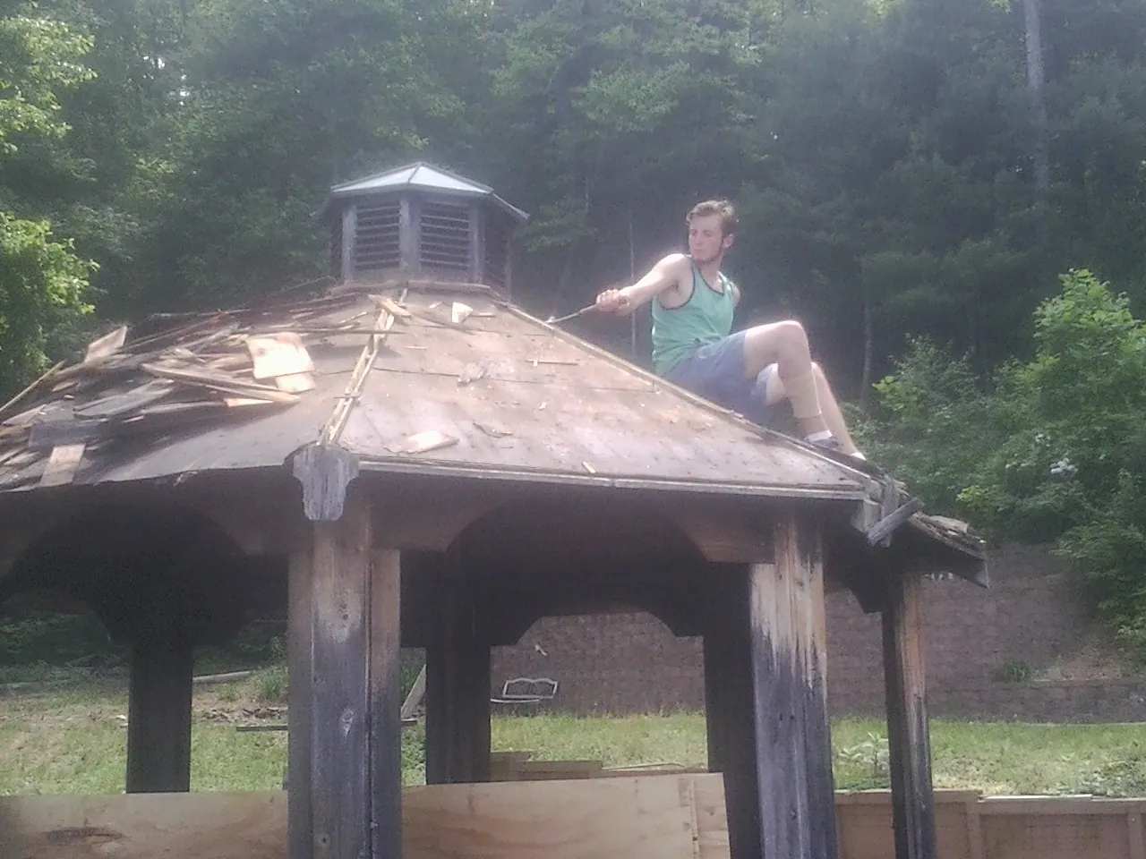 Tearing the old roof off a wooden gazebo before new shakes in Stanwood